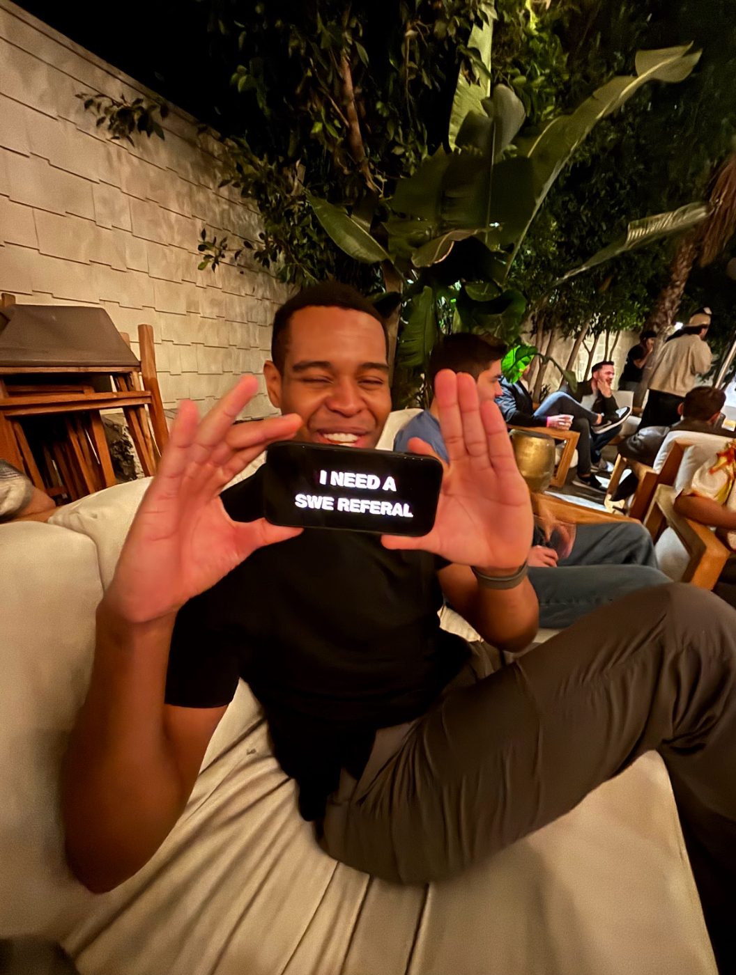 Holding up a phone that reads I need a SWE referral